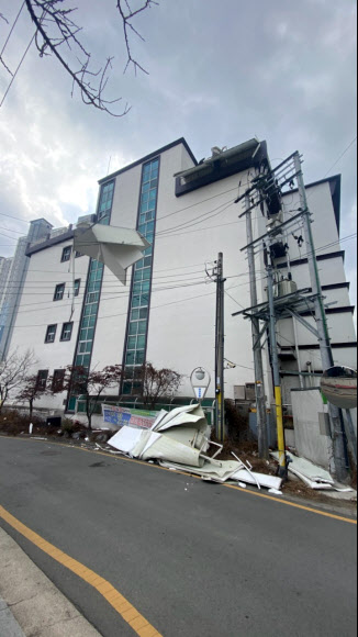 28일 오후 대구지역에 강풍이 불며 대구 동구 괴전동의 한 전봇대 전깃줄에 바람에 날아온 패널이 걸려 있다. 2021.1.28  대구소방안전본부 제공