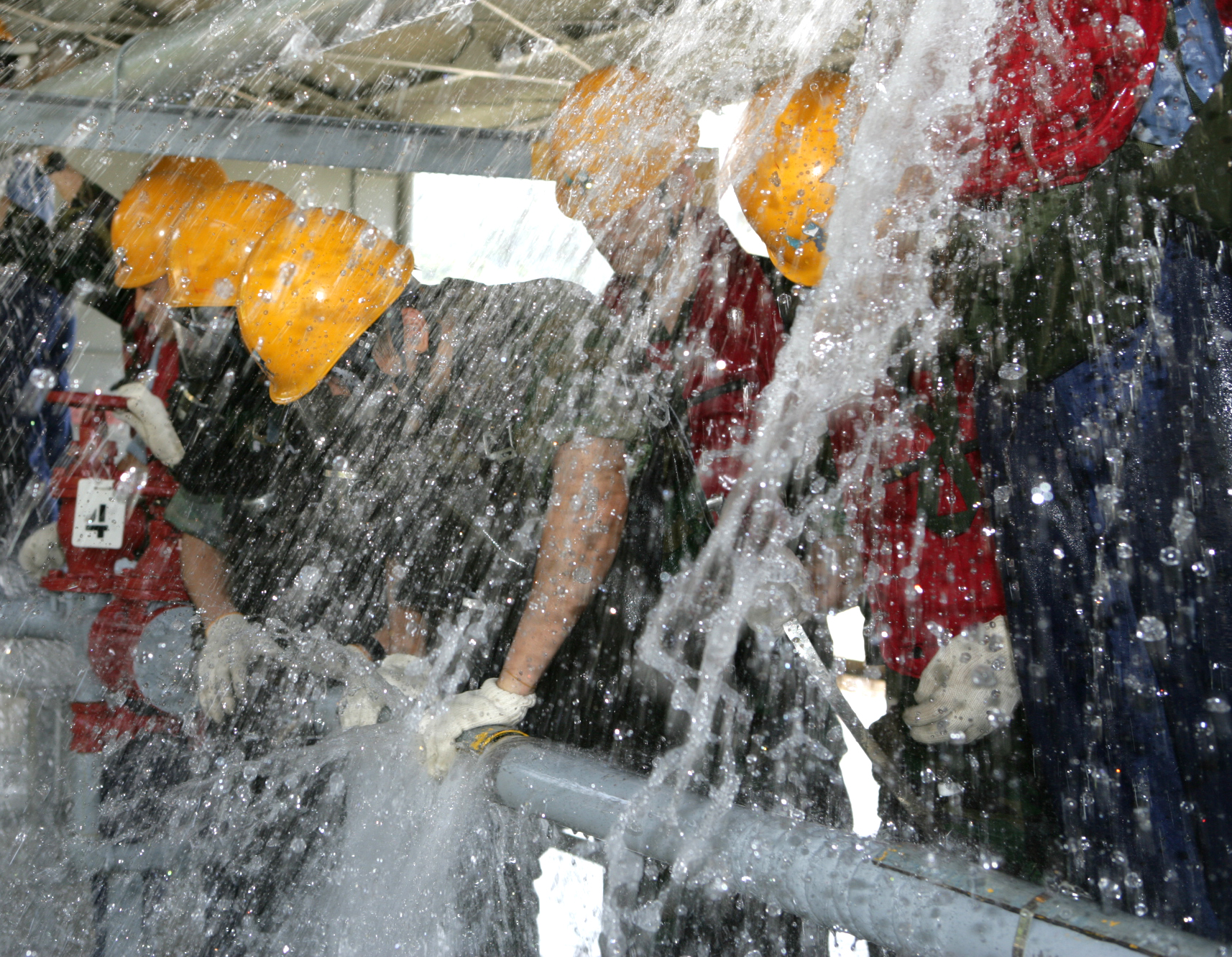 소화방수훈련에 참가한 해군 대원들이 온 몸으로 쏟아져 나오는 물을 막고 있다. 해군 제공