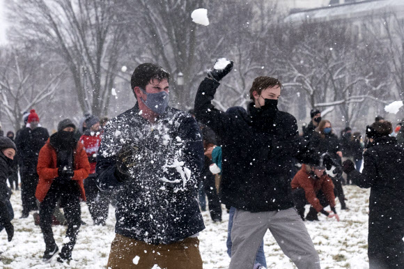 사람들이 1일(현지시간) 미국 워싱턴 내셔널 몰의 스미스소니언 캐슬 근처에서 워싱턴 DC 스노우볼 파이트 협회가 주최한 눈싸움 중 눈덩이를 던지고 있다. AP 연합뉴스 