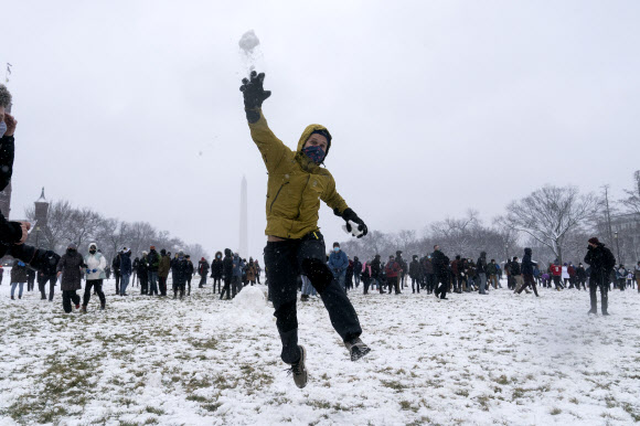 사람들이 1일(현지시간) 미국 워싱턴 내셔널 몰의 스미스소니언 캐슬 근처에서 워싱턴 DC 스노우볼 파이트 협회가 주최한 눈싸움 중 눈덩이를 던지고 있다. AP 연합뉴스 