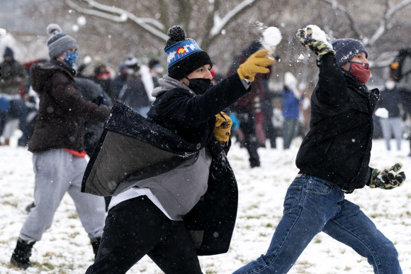 사람들이 1일(현지시간) 미국 워싱턴 내셔널 몰의 스미스소니언 캐슬 근처에서 워싱턴 DC 스노우볼 파이트 협회가 주최한 눈싸움 중 눈덩이를 던지고 있다. AP 연합뉴스