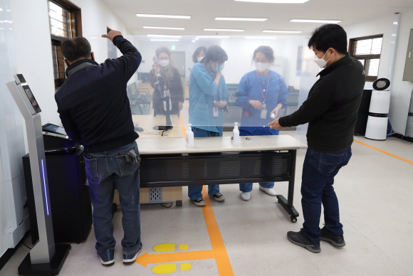 코로나 19 예방접종 대응 추진단과 국립중앙의료원이 코로나19 중앙예방접종센터 지정에 따라 1일 시설을 완비하고 운영개시를 앞두고 있다. 접종대사자 등록을 하는 대기구역에서 의료원 관계자들이 가림막을 설치하고 있다. 2021. 2. 1 정연호 기자 tpgod@seoul.co.kr