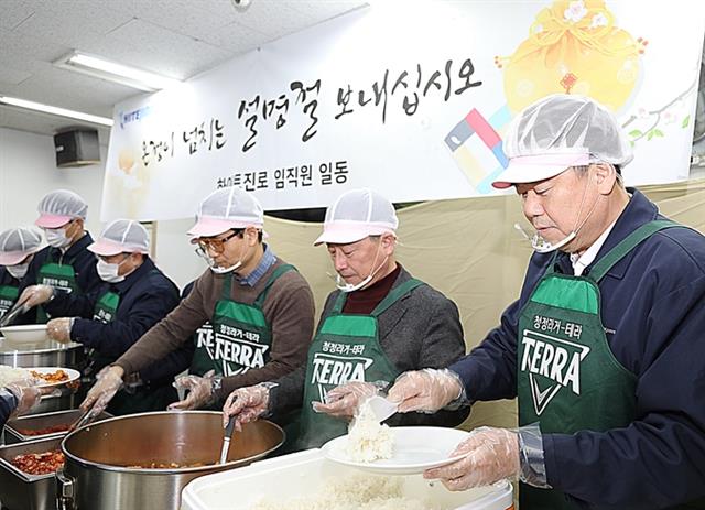 김인규(오른쪽 첫 번째) 하이트진로 사장과 임직원들이 지난달 23일 서울역 인근 무료급식소 ‘따스한 채움터’에서 노숙인들에게 배식 나눔 봉사 활동을 하고 있다. 하이트진로 제공