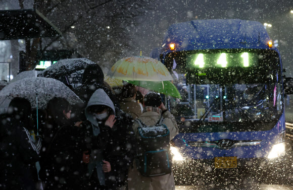 큰 눈이 내린 3일 밤 서울 서초구 강남대로에서 시민들이 귀가 버스를 기다리고 있다. 2021.2.3 연합뉴스