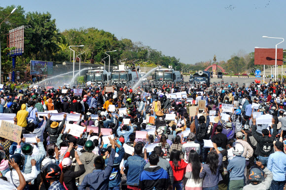 9일(현지시간) 미얀마 수도 네피도에서 열린 군부 쿠데타 항의 시위에서 경찰이 시위대를 향해 물대포를 쏘고 있다.  네피도 AFP 연합뉴스