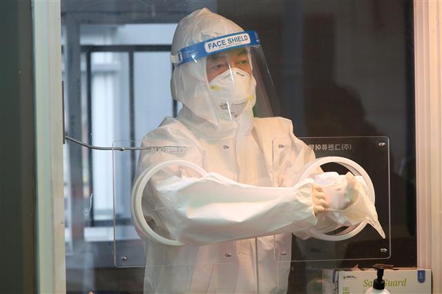 서울시장 보궐선거에 출사표를 던진 안철수 국민의당 대표가 설 명절 연휴 첫날인 11일 오전 중구 봉래동 서울역 광장에 마련된 신종 코로나바이러스 감염증(코로나19) 중구 임시선별검사소에서 의료지원을 나와 검체 체취를 준비하고 있다. 2021.2.11 뉴스1