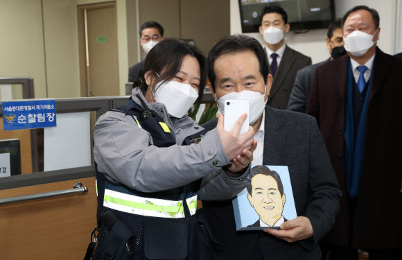 정세균 국무총리가 설 연휴 첫날인 11일 서울시 동대문구 제기파출소를 방문, 근무 중인 경찰관과 셀카를 촬영하고 있다. 2021.2.11  연합뉴스