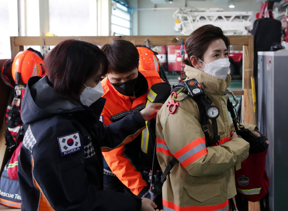 서울시장 보궐선거 국민의힘 나경원 예비후보가 설 연휴 첫날인 11일 서울 은평소방서를 방문, 관계자의 도움을 받아 장비 착용을 하고 있다. 2021.2.11   나경원 예비후보 측 제공