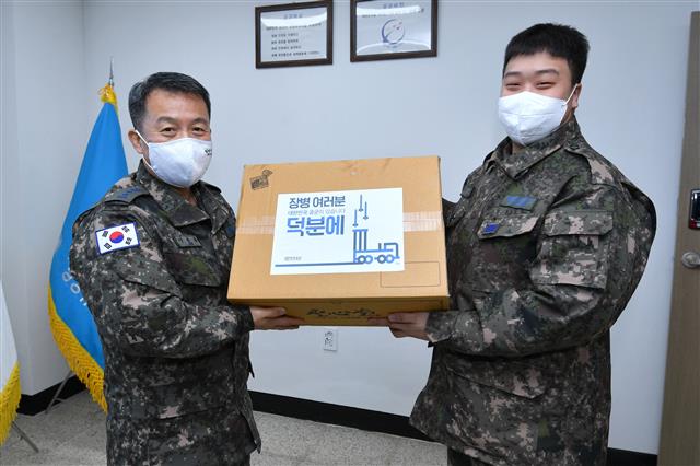 이성용 공군참모총장(왼쪽)이 설 연휴 첫날인 11일 공군 제8311부대와 제8785부대를 방문해 장병들을 위한 간식으로 튀김 소보로빵을 부대 으뜸병사(오른쪽)에게 직접 전달하고 있다.  이성용 공군참모총장은 “설 연휴에도 충실히 임무를 수행중인 장병들이 든든하고 자랑스럽다”며 장병들을 격려했다. 2021.2.11 공군 제공