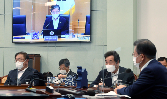 문재인(오른쪽) 대통령이 16일 청와대에서 화상회의 형식으로 진행된 국토교통부 2021년 업무보고에서 변창흠(화면) 국토부 장관의 보고를 받고 있다. 도준석 기자 pado@seoul.co.kr