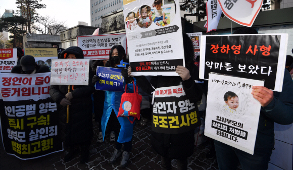 입양부모의 학대로 숨진 ‘정인이 사건’ 증인신문이 열린 17일 서울 양천구 서울남부지법 앞에서 시민들이 입양부모의 엄벌을 촉구하는 내용의 피켓을 들고 서 있다. 박지환 기자 popocar@seoul.co.kr