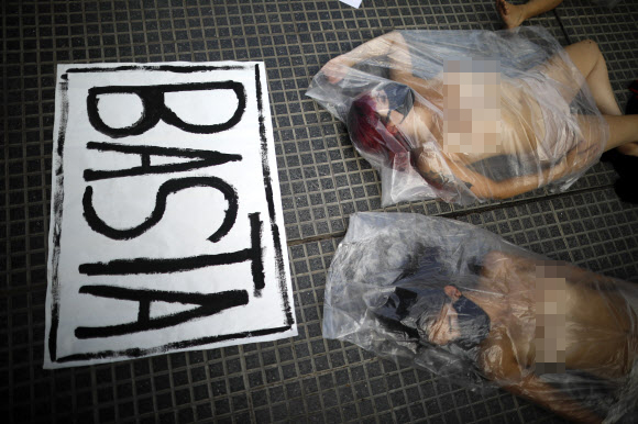 여성들이 17일(현지시간) 아르헨티나 부에노스아이레스에서 나체로 비닐백에 들어가 여성 폭력에 대한 항의 시위를 하고 있다. 스페인어로 ‘단 한 명의 여성도 잃을 수 없다’(Ni Una Menos)라고 명명된 이 여성운동 단체 회원들은 ‘우르술라 바이요’라는 이름의 여성이 자신을 괴롭히던 남성을 십여 차례 고소했다가 지난 8일 그에게 살해된 사건이 판사들의 부주의 때문이라고 주장하며 시위를 벌였다. AFP 연합뉴스