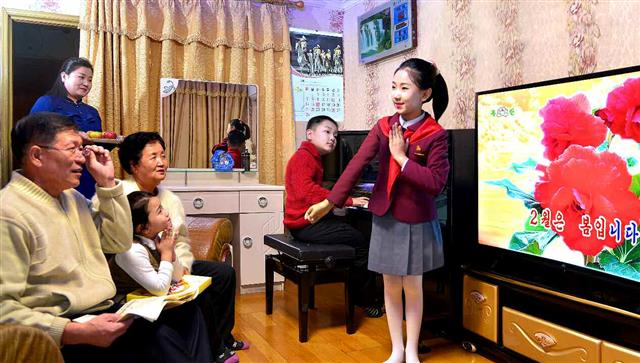 북한 노동당 기관지 노동신문은 17일 ‘장미꽃에 깃든 사연’이라는 제목의 기사를 통해 “김정일 국방위원장의 사랑을 전하기 위해” 장미 재배에 힘쓴 원산시화초사업소가 노력한 사연을 보도했다. 사진은 한 가정에서 장미가 나온 영상을 배경으로 노래를 부르는 어린이의 모습. 신문은 “한없는 그리움을 노래에 담아간다”라고 설명했다. 뉴스1   [국내에서만 사용가능. 재배포 금지. DB 금지. For Use Only in the Republic of Korea. Redistribution Prohibited]  rodongphoto@news1.kr