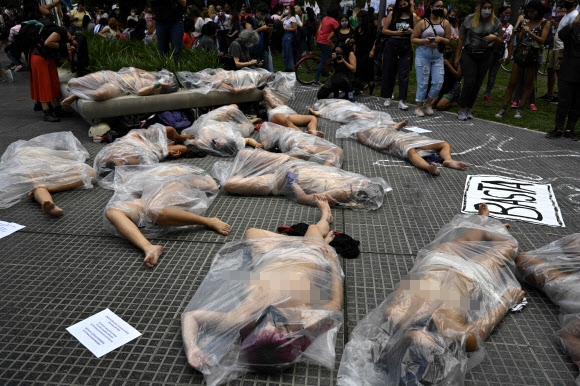 여성들이 17일(현지시간) 아르헨티나 부에노스아이레스에서 나체로 비닐백에 들어가 여성 폭력에 대한 항의 시위를 하고 있다. 스페인어로 ‘단 한 명의 여성도 잃을 수 없다’(Ni Una Menos)라고 명명된 이 여성운동 단체 회원들은 ‘우르술라 바이요’라는 이름의 여성이 자신을 괴롭히던 남성을 십여 차례 고소했다가 지난 8일 그에게 살해된 사건이 판사들의 부주의 때문이라고 주장하며 시위를 벌였다. AFP 연합뉴스