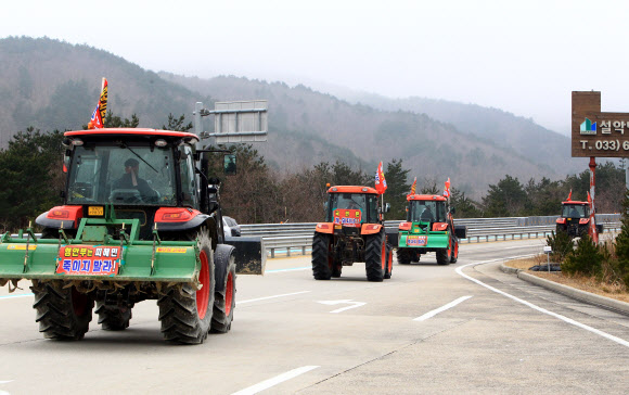 정부의 구상권 청구방침에 항의하는 트랙터 반납시위에 나선 강원 고상산불 이재민들이 22일 미시령톨게이트를 통과해 강원도청으로 향하고 있다. 이날 시위에 참여한 이재민은 15명으로 이들은 정부의 구상권 청구방침에 따라 농림축산식품부와 강원도로부터 지원을 받아 구매한 트랙터를 강원도에 현물로 반납하기로 했다. 2021.2.22  연합뉴스