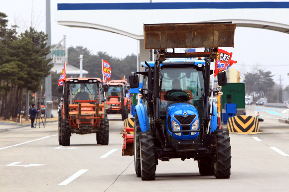 정부의 구상권 청구방침에 항의하는 트랙터 반납시위에 나선 강원 고상산불 이재민들이 22일 미시령톨게이트를 통과해 강원도청으로 향하고 있다. 이날 시위에 참여한 이재민은 15명으로 이들은 정부의 구상권 청구방침에 따라 농림축산식품부와 강원도로부터 지원을 받아 구매한 트랙터를 강원도에 현물로 반납하기로 했다. 2021.2.22  연합뉴스