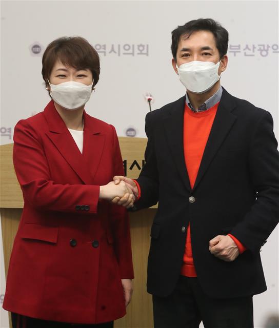 이언주(왼쪽), 박민식 국민의힘 부산시장 경선후보가 22일 오전 부산 연제구 부산시의회 브리핑룸에서 단일화 합의문 내용을 발표 후 손을 맞잡고 있다. 23일 여론조사를 거쳐 24일 단일화 결과를 발표할 예정이다. 2021.2.22 뉴스1