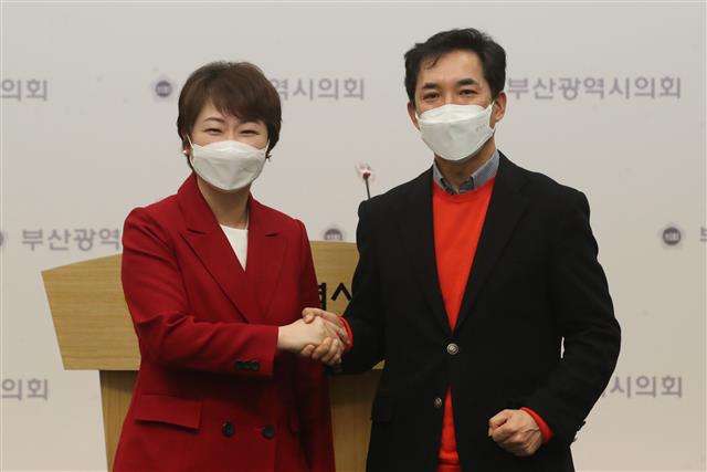 이언주(왼쪽), 박민식 국민의힘 부산시장 경선후보가 22일 오전 부산 연제구 부산시의회 브리핑룸에서 단일화 합의문 내용을 발표 후 손을 맞잡고 있다. 23일 여론조사를 거쳐 24일 단일화 결과를 발표할 예정이다. 2021.2.22 뉴스1