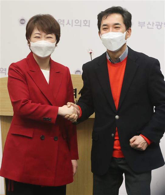 이언주(왼쪽), 박민식 국민의힘 부산시장 경선후보가 22일 오전 부산 연제구 부산시의회 브리핑룸에서 단일화 합의문 내용을 발표 후 손을 맞잡고 있다. 국민의힘은 23일 여론조사를 거쳐 24일 단일화 결과를 발표할 예정이다. 2021.2.22 뉴스1