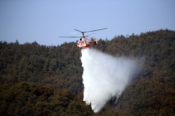 22일 경북 안동시 임동면 일대에서 소방헬기들이 산불을 진화하고 있다. 전날 오후 임동면 망천리 야산에서 시작된 산불은 수 ㎞ 떨어진 중평리까지 번져 인근 주민 108명이 몸을 피했다. 소방당국과 산림청은 이날 오후 주불 진화를 마쳤다. 2021.2.22  연합뉴스