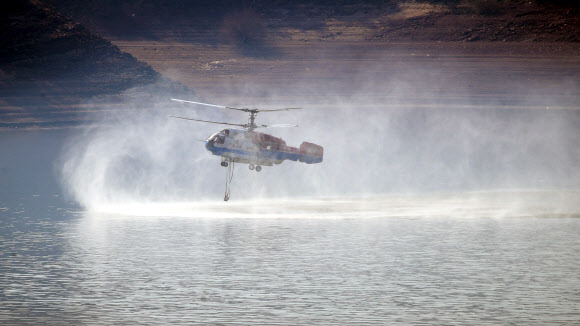 22일 경북 안동시 임동면 일대 저수지에서 소방헬기기 산불진화를 위해 물을 담고 있다. 전날 오후 임동면 망천리 야산에서 시작된 산불은 수 ㎞ 떨어진 중평리까지 번져 인근 주민 108명이 몸을 피했다. 소방당국과 산림청은 이날 오후 주불 진화를 마쳤다. 2021.2.22  연합뉴스