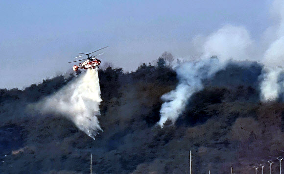 22일 경북 안동시 임동면 일대에서 소방헬기들이 산불을 진화하고 있다. 전날 오후 임동면 망천리 야산에서 시작된 산불은 수 ㎞ 떨어진 중평리까지 번져 인근 주민 108명이 몸을 피했다. 소방당국과 산림청은 이날 오후 주불 진화를 마쳤다. 2021.2.22  연합뉴스