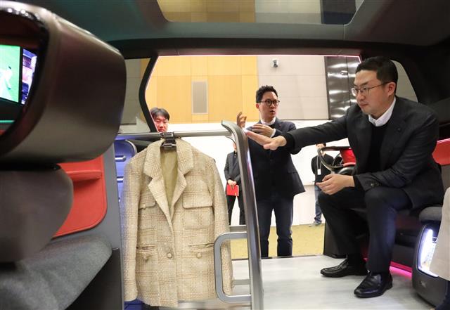 구광모(오른쪽) LG그룹 회장이 지난해 2월 서울 서초구 LG전자 디자인경영센터를 방문해 미래형 커넥티드카(정보통신 기술로 연결된 차량) 내부에 설치된 의류관리기의 디자인을 살피고 있다. LG그룹 제공