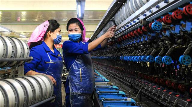 북한 노동당 기관지 노동신문은 24일 ‘하나는 전체를 위하여, 전체는 하나를 위하여’라는 이 구호가 “전구마다에서 울려나오고 있다”라고 보도했다. 이어 이 구호엔 “뜨거운 정과 사랑”이 담겨있다면서 “모두가 서로 돕고 이끌면서 전진”해야 한다고 촉구했다. 사진은 이 같은 사례로 신문이 소개한 김정숙평양제사공장의 노동자들의 모습. 평양 노동신문=뉴스1