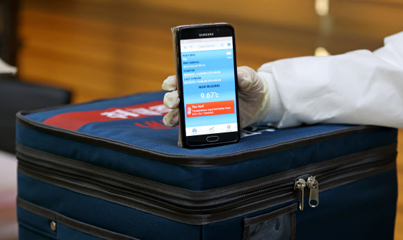 23일 오후 국내 아스트라제네카(AZ) 백신 운송 용기의 공급을 맡은 콜드체인 전문기업 에프엠에스코리아에서 직원이 백신 운송 용기와 함께 사용되는 스마트 센서 이용 모습을 보여주고 있다. 운송 용기 내부 온도가 AZ백신 보관 적정 온도에서 이탈되면 안내문이 표시된다. 이 온도 측정 센서를 통해 백신이 의료기관에 도착해 접종되기까지 운송 용기 내부 온도를 확인할 수 있다. 2021.2.24  연합뉴스