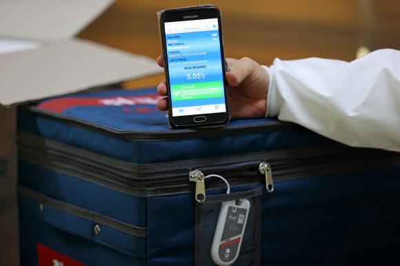 23일 오후 국내 아스트라제네카(AZ) 백신 운송 용기의 공급을 맡은 콜드체인 전문기업 에프엠에스코리아에서 직원이 백신 운송 용기와 함께 사용되는 스마트 센서 이용 모습을 보여주고 있다. 이 온도 측정 센서를 통해 백신이 의료기관에 도착해 접종되기까지 운송 용기 내부 온도를 확인할 수 있다. 2021.2.24  연합뉴스