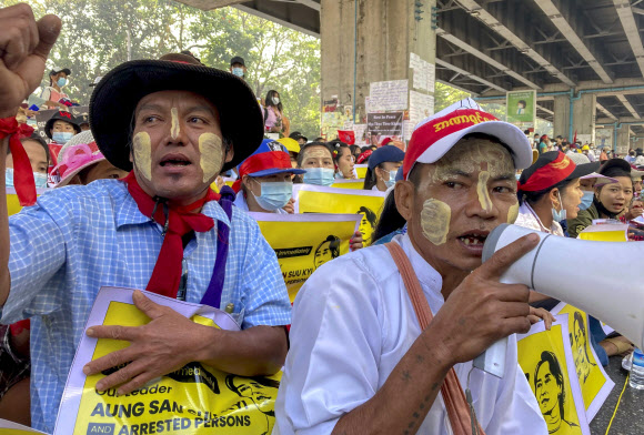 25일 미얀마 양곤에서 열린 쿠데타 반대 시위에서 시민들이 전통화장품 ‘타나카’를 얼굴에 바른 채 구호를 외치고 있다. 양곤 AP 연합뉴스