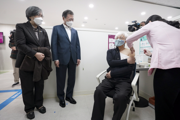 문재인 대통령이 백신 접종이 시작된 26일 오전 서울 마포구보건소를 방문, 정은경 질병관리청장과 함께 재활시설 종사자인 김윤태 의사(푸르메 넥슨어린이 재활병원)가 아스트라제네카(AZ) 백신을 접종받는 모습을 지켜보고 있다. 2021. 2. 26   도준석 기자 pado@seoul.co.kr