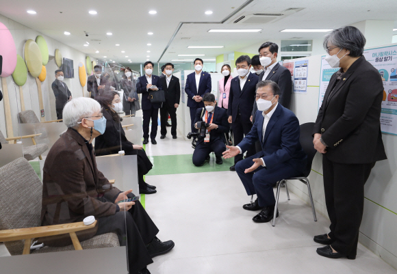 문재인 대통령이 코로나19 접종이 시작된 26일 오전 서울 마포구 성산동 마포구보건소에서 찾아 정은경 질병관리청장(오른쪽)과 함께 접종 상황을 살펴본 뒤 접종을 한 김윤태 푸르메 넥슨어린이 재활병원장(왼쪽), 이정선 시립서부노인전문선터 작업치료사(왼쪽 둘째)와 이상반응 관찰실에서 이야기를 나누고 있다. 2021. 2. 26   도준석 기자 pado@seoul.co.kr