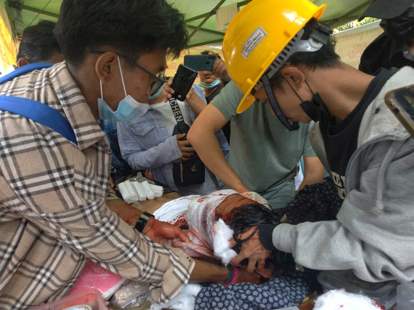미얀마에 군부 쿠데타가 발생한 지 4주가 되는 28일 양곤에서 제2차 총파업에 동조한 이들이 군경이 총격을 가해 다친 남성을 구호하기 위해 안간힘을 쓰고 있다. 양곤 EPA 연합뉴스 