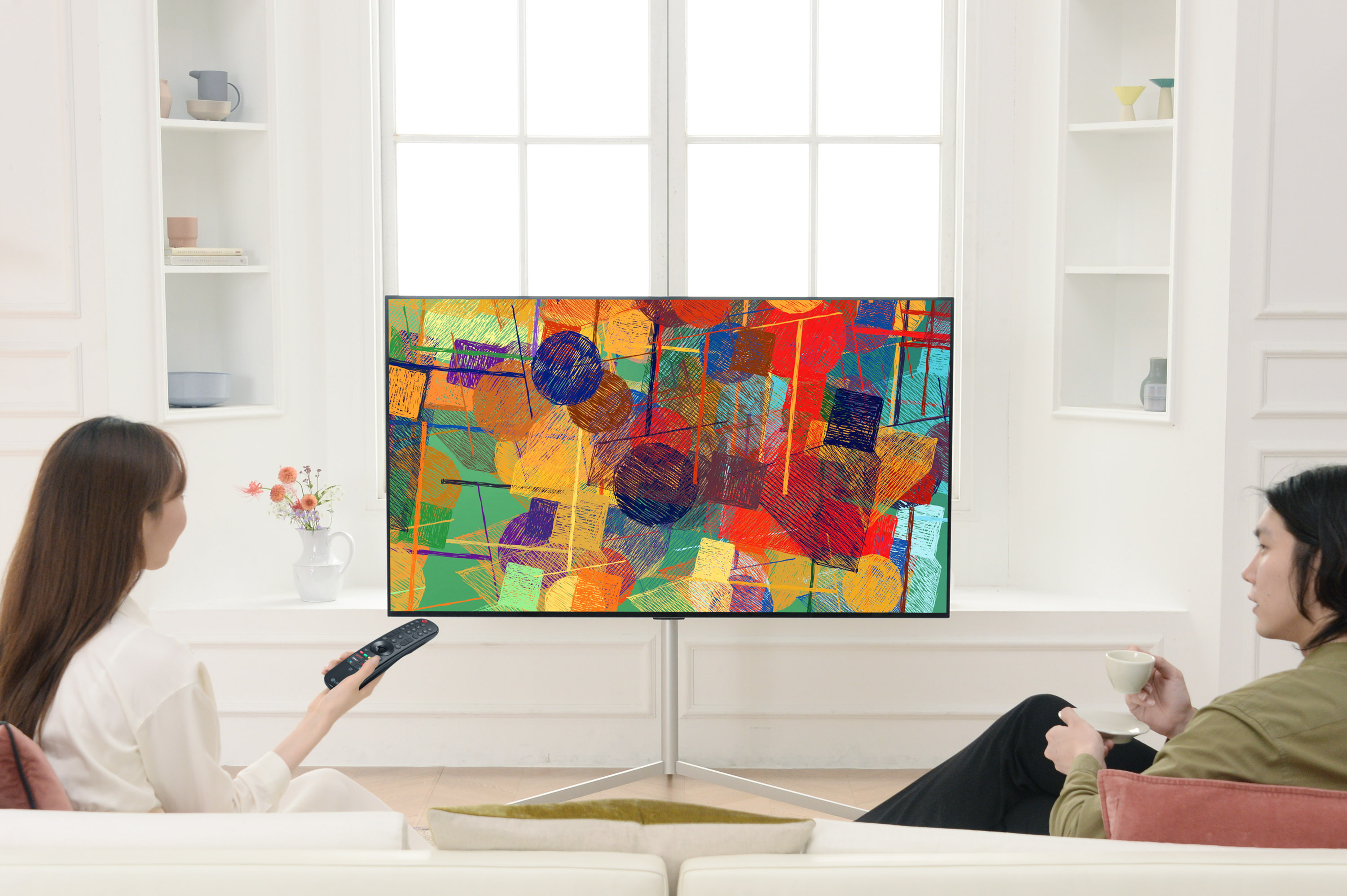 LG전자가 1일 2021년형 LG 올레드 TV 신제품인 ‘올레드 에보’를 출시한 가운데 모델이 가정 공간을 배경으로 배치된 제품을 감상하고 있다.  LG전자 제공