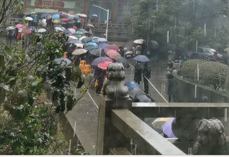 화시촌 파산 위기설이 나돌면서 이곳 주민들이 투자한 돈을 되돌려받기 위해 빗 속에 우산을 쓴채 장사진을 치고 있다. 펑황망 홈페이지 캡처