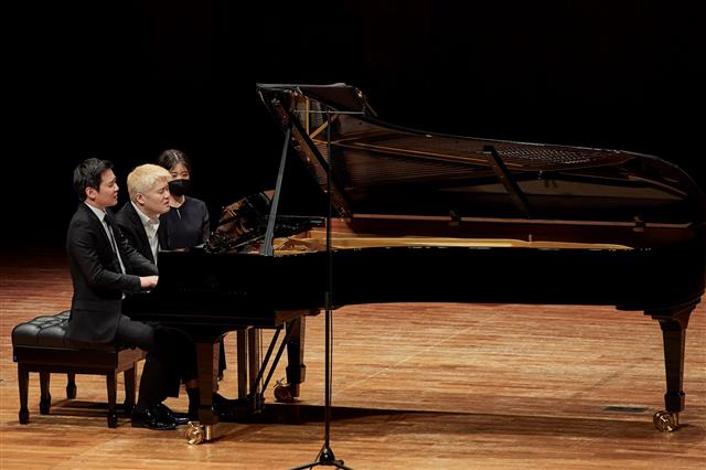 피아니스트 임동민(가운데)·임동혁(왼쪽) 형제가 3일 서울 예술의전당 콘서트홀에서 슈베르트 ‘네 손을 위한 환상곡’을 연주하고 있다.  크레디아 제공