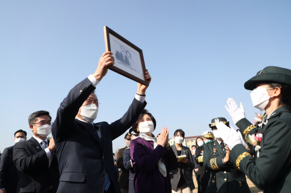 문재인 대통령과 김정숙 여사가 5일 대전광역시 국군간호사관학교에서 열린 제61기 졸업 및 임관식을 마친 후 식장을 떠나며 졸업 생도로부터 받은 선물을 들어 보이고 있다. 2021.3.5 도준석기자 pado@seoul.co.kr