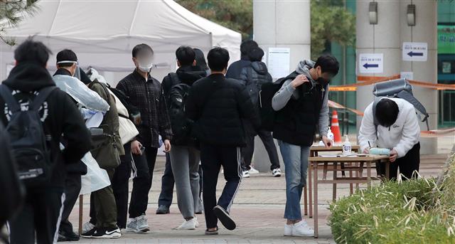 2021년 1차 경찰공무원(순경) 채용 필기시험이 치러진 6일 오전 서울 중구 성동공업고등학교 고사장으로 응시생들이 들어가기 전 문진표를 작성하고 있다.  경찰청에 따르면 이번 시험에는 2907명 선발 예정에 4만6687명이 응시해 16대 1의 경쟁률을 기록했다. 2021.3.6 뉴스1