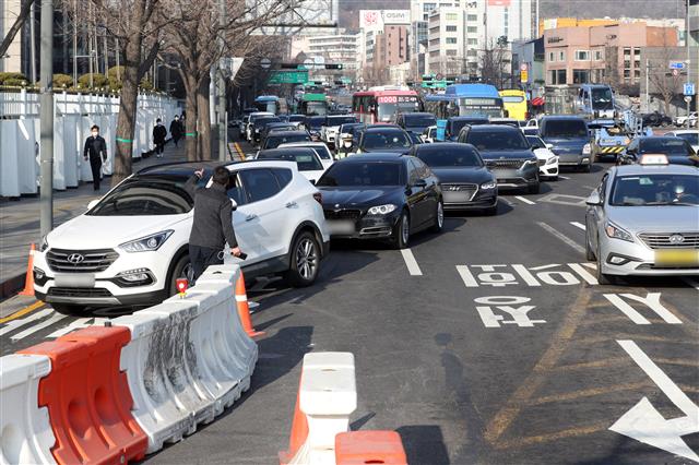 광화문광장 교통체계가 바뀌고 첫 출근날인 8일 광화문 교차로에서 우회전 차량들이 혼잡을 빚고 있다. 서울시는 지난 6일 0시부터 광화문광장 서측도로를 폐쇄하고 동측도로 양방향 통행을 시작했다.  2021.3.8 뉴스1