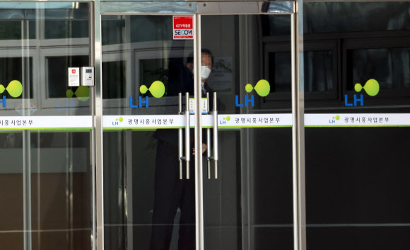 경기남부경찰청 반부패경제범죄수사대가 ‘LH임직원 신도시 투기’ 의혹 수사와 관련해 LH 본사 등에 대해 압수수색을 진행한 9일 오전 경기 광명 한국토지주택공사(LH) 광명시흥사업본부에서 한 직원이 문을 잠그고 있다. 2021.3.9  연합뉴스