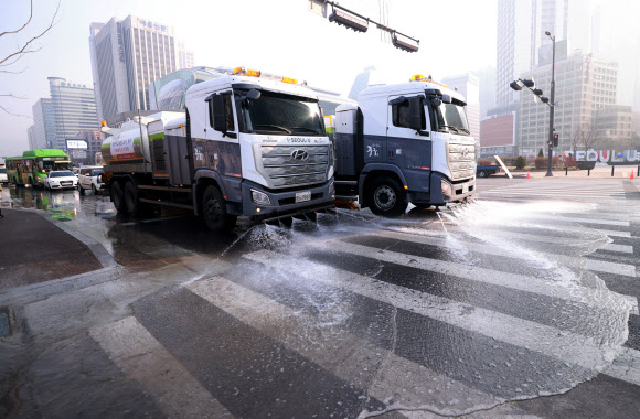 서울과 인천, 경기 등 수도권 전역에 미세먼지 비상저감조치가 시행된 11일 오전 서울 중구 태평로 덕수궁 대한문 앞에서 중구청 물청소 차량이 도로 물청소를 하고 있다. 2021.3.11  연합뉴스