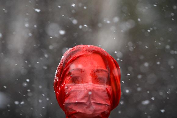 붉은색 베일은 쓴 여성이 10일(현지시간) 루마니아 부쿠레슈티에서 코로나19 대유행이 시작된 후 여성 폭력이 늘어난 것을 항의하는 시위를 벌이고 있다. AP 연합뉴스