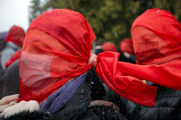 붉은색 베일은 쓴 여성들이 10일(현지시간) 루마니아 부쿠레슈티에서 코로나19 대유행이 시작된 후 여성 폭력이 늘어난 것을 항의하는 시위를 벌이고 있다. AP 연합뉴스