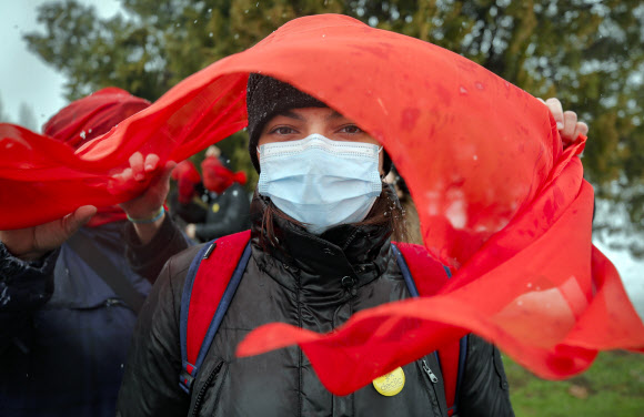 붉은색 베일은 쓴 여성이 10일(현지시간) 루마니아 부쿠레슈티에서 코로나19 대유행이 시작된 후 여성 폭력이 늘어난 것을 항의하는 시위를 벌이고 있다. AP 연합뉴스