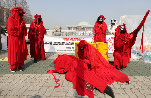 종교환경회의, 불교환경연대 관계자들이 11일 서울 여의도 국회 앞에서 후쿠시마 핵발전소 사고 10주년 탈핵 행진 기자회견을 열고 탈핵을 촉구하는 퍼포먼스를 벌이고 있다. 2021.3.11 연합뉴스