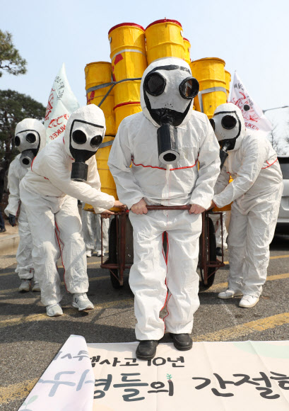 종교환경회의, 불교환경연대 관계자들이 11일 서울 여의도 LG트윈타워 앞에서 후쿠시마 핵발전소 사고 10주년 탈핵 행진을 하고 있다. 2021.3.11 연합뉴스