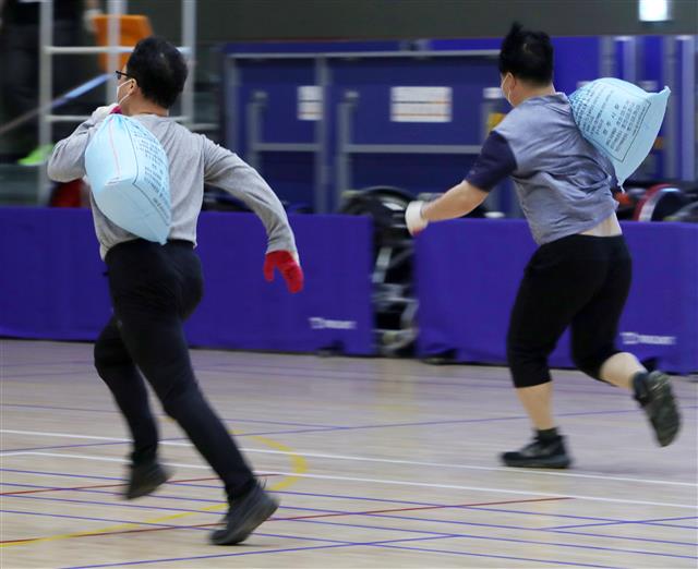 11일 전북 전주시 전주어울림국민체육센터에서 열린 ‘전주시 환경관리원 채용 체력평가’에서 응시자들이 모래주머니 메고 달리기를 하고 있다. 2021.3.11 뉴스1