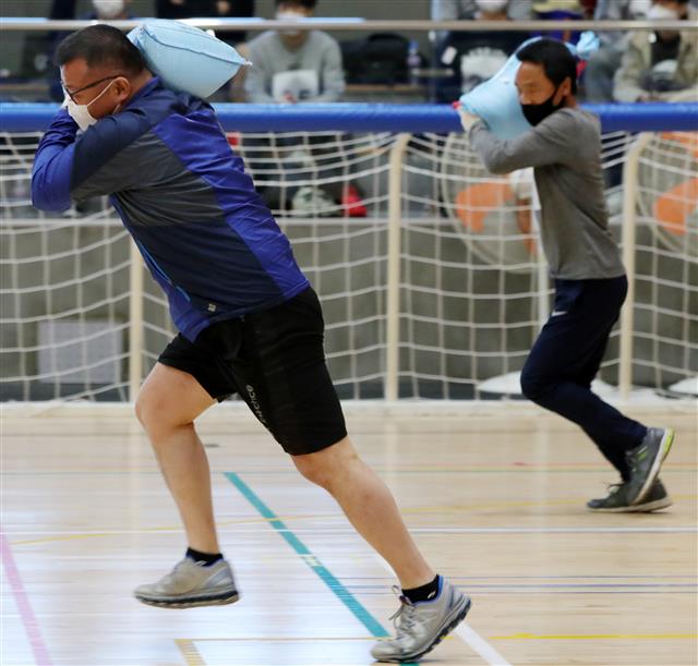 11일 전북 전주시 전주어울림국민체육센터에서 열린 ‘전주시 환경관리원 채용 체력평가’에서 응시자들이 모래주머니 메고 달리기를 하고 있다. 2021.3.11 뉴스1