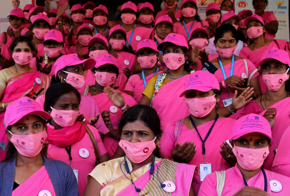8일(현지시간) 인도 벵갈루루에서 공인사회건강활동가(ASHA) 모임의 여성 활동가들이 세계 여성의날 기념 행사에 분홍색 옷과 마스크를 맞춰 입고 참석한 모습. 벵갈루루 EPA 연합뉴스